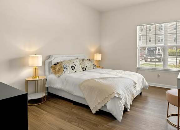 A bedroom with a large bed, a desk, and a chair.
