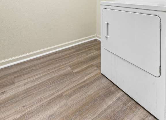 Laundry room with white dryer and wire shelving at Northampton Village Apartments, Indianapolis