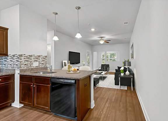 A kitchen with a black dishwasher and a black fridge.