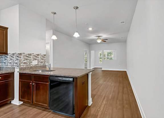 A kitchen with wooden cabinets and a black dishwasher.