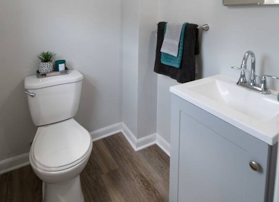 A white toilet sits next to a sink in a small bathroom.