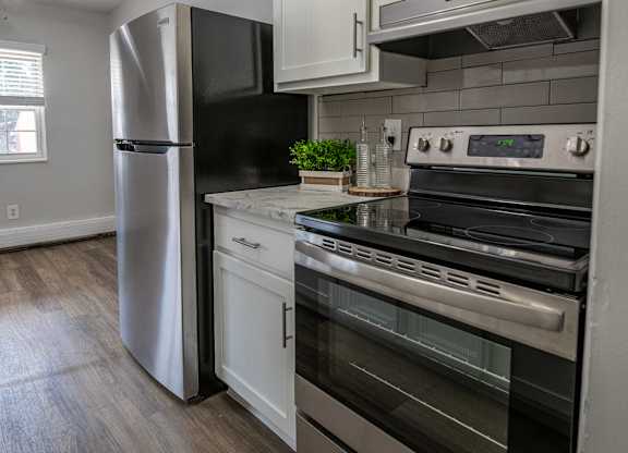A modern kitchen with a stainless steel refrigerator and oven.