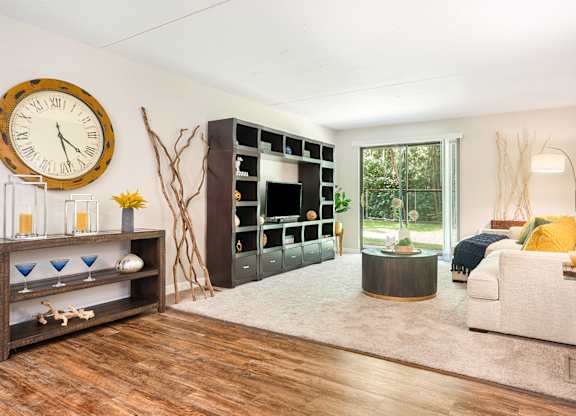 A living room with a large clock on the wall.