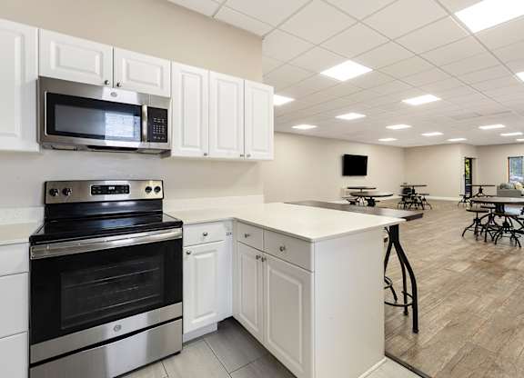 A kitchen with white cabinets and a black stove top oven.