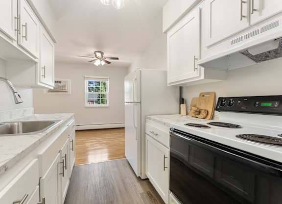 A kitchen with white cabinets and a black stove top oven.