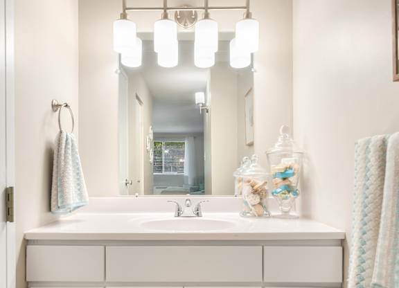 Well-lit vanities with extra cabinet storage in every apartment.