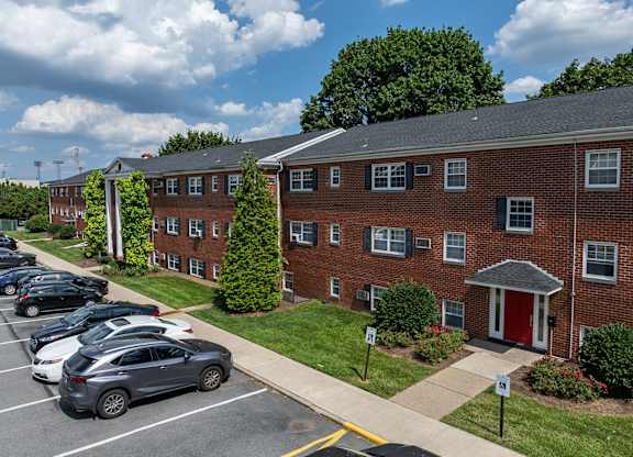 A parking lot with cars parked in front of a brick building.