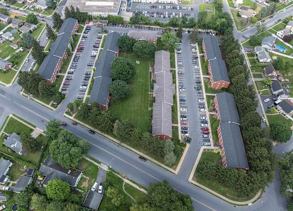 A parking lot with cars and apartment buildings.