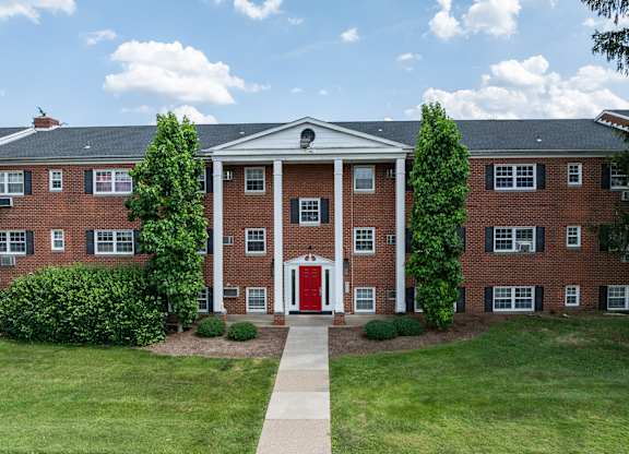 A red brick building with a white door and windows.