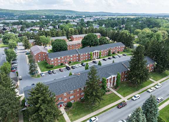 A large red brick building with a parking lot in front.