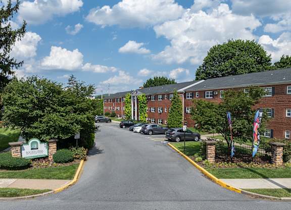 A street view of a residential area with cars parked on the side of the road.
