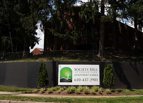 A sign for Society Hill Apartment Homes is displayed in front of a building.