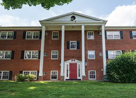 A red brick building with a white door and windows.