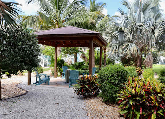 A gazebo surrounded by greenery and trees.