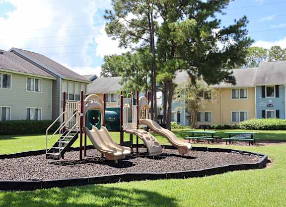A playground with a slide and a green slide cover.