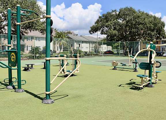 A playground with green equipment and a green fence.