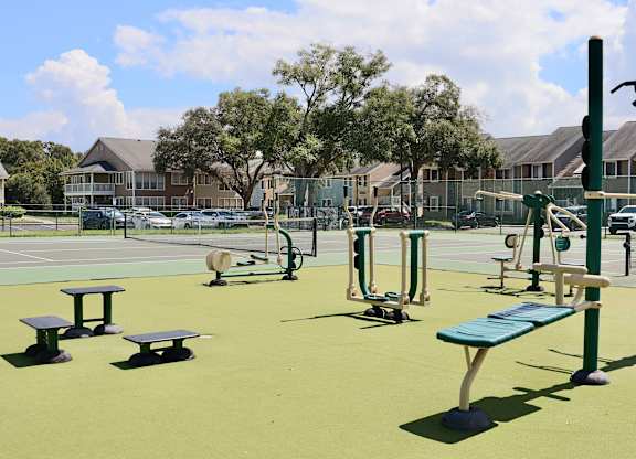 A playground with a green surface and a blue bench.