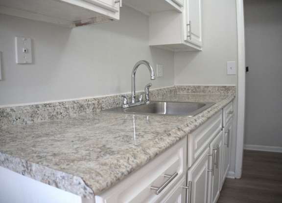 a kitchen with marble counter tops and a sink