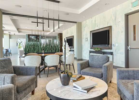 A living room with grey chairs and a white coffee table.