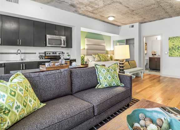 A living room with a grey couch and a green bowl on the coffee table.