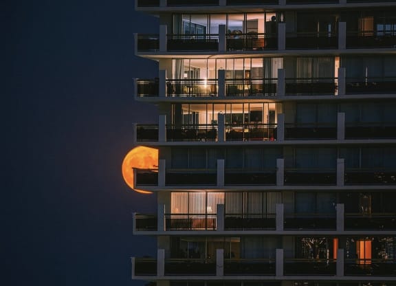 the moon is projected on the side of a building at night