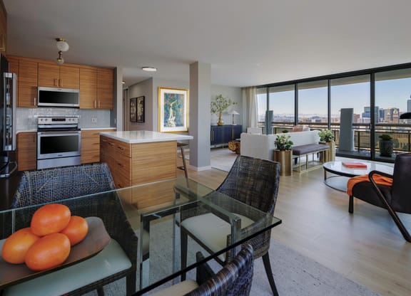 a living room and kitchen with a glass table and chairs