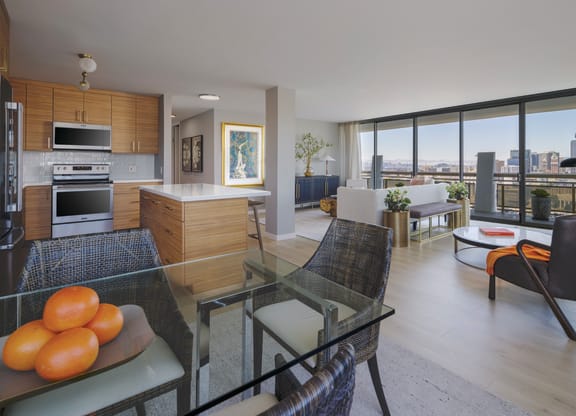 a living room and kitchen with a glass table and chairs
