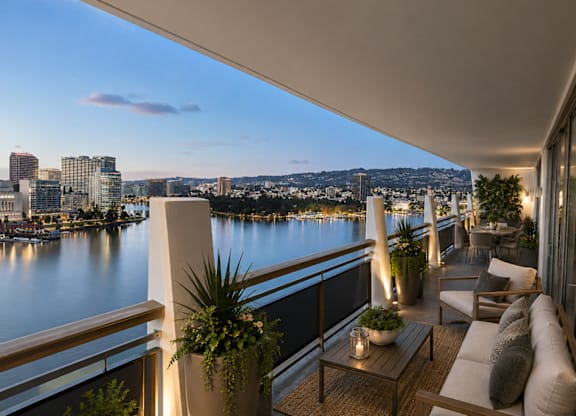 A balcony with a view of a city skyline at dusk.