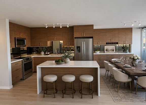 A modern kitchen with a central island and bar stools.