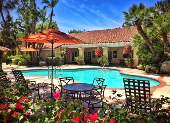 a swimming pool in front of a house with a pool table and umbrella at Victoria Springs, Riverside California
