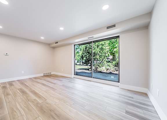A room with a large window and wooden flooring.