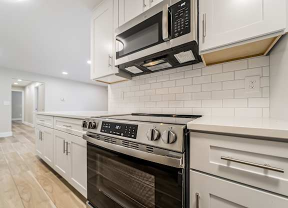 A modern kitchen with a stainless steel oven and microwave.