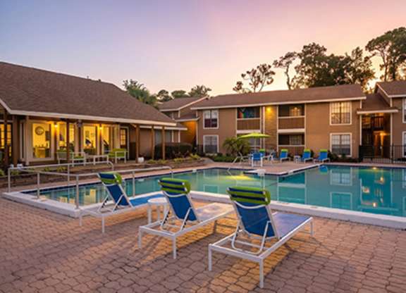 A poolside area with lounge chairs and a swimming pool.