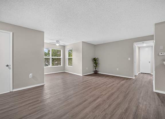 A room with wooden flooring and white walls.