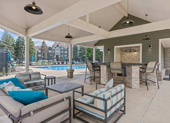 A covered patio with a pool in the background.