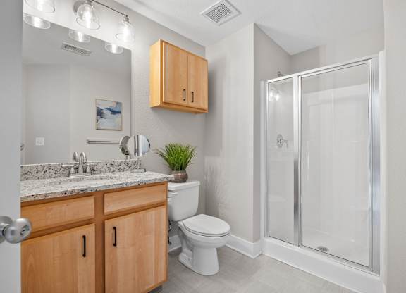 A bathroom with a toilet, sink, and shower.