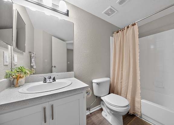 A bathroom with a toilet, sink, and bathtub.