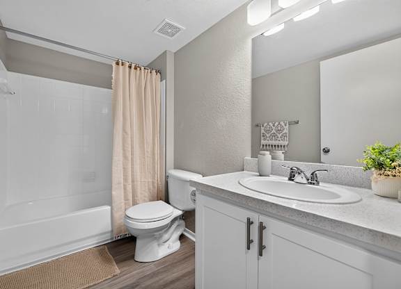 A white toilet sits in a bathroom next to a sink.