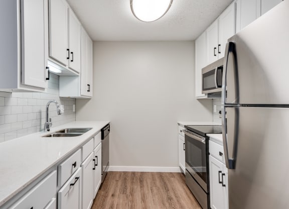 Upgraded Kitchen with White Cabinetry and Stainless Steel Appliances