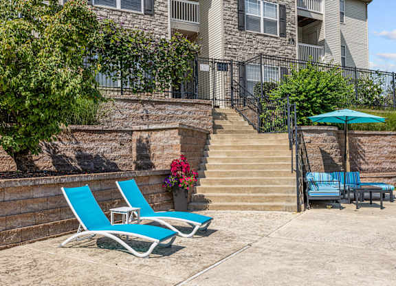 Two blue chairs and lounge area with umbrella on the sundeck.
