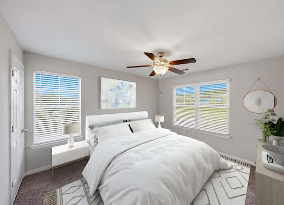 A bedroom with a large bed, expansive windows, and a ceiling fan.