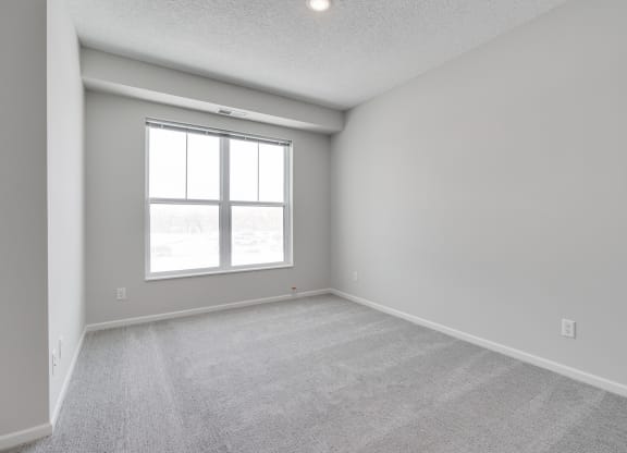 Bedroom Featuring Plush Carpeting & Large Windows