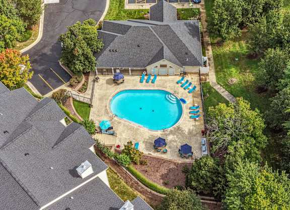 A swimming pool surrounded by trees and a house.