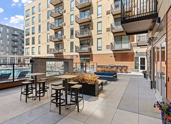 A patio with a table and chairs is surrounded by apartment buildings.