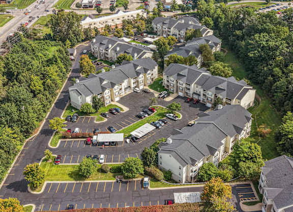 A bird's eye view of a residential area with houses and a parking lot.