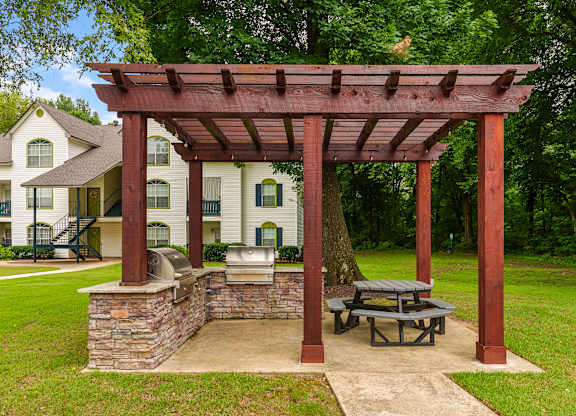A wooden pergola with a picnic table underneath it.