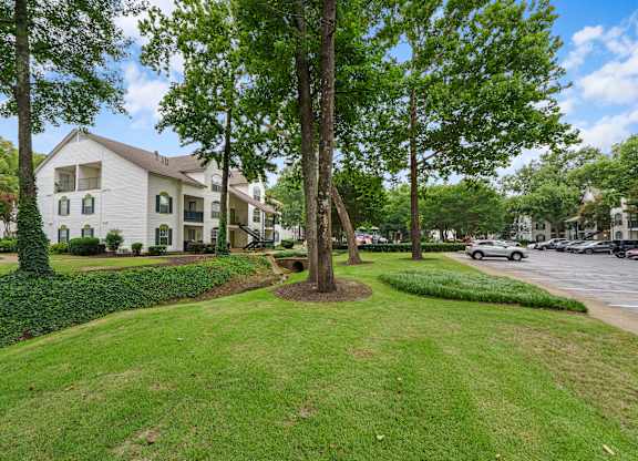 Lush grass and tree area in front of an apartment building