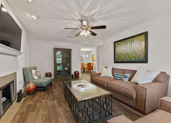 A living room with a brown couch and a fireplace.