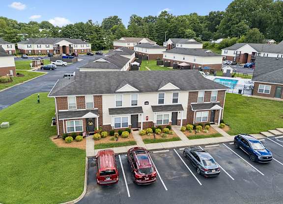 A parking lot with cars and apartment buildings in the background.