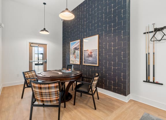 a dining room with a table and chairs and a black accent wall
